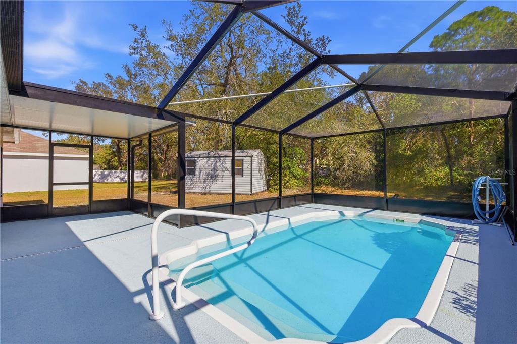 A single-story white house with a black garage door and a concrete driveway — 4320 BAYRIDGE COURT, SPRING HILL, FL