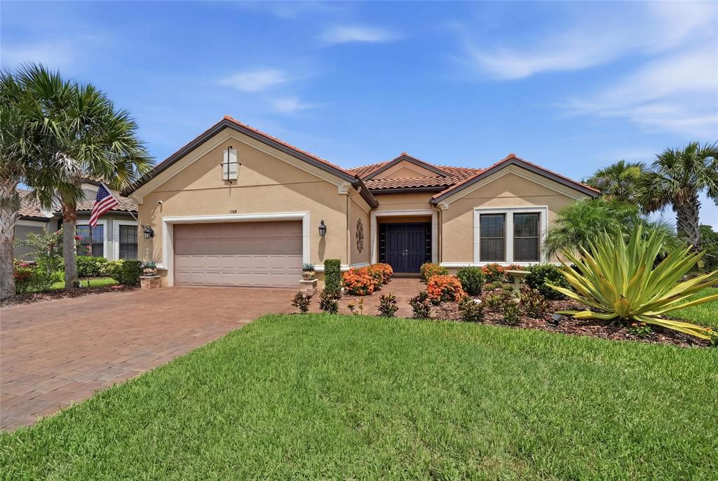 A single-story stucco house with a tile roof, two-car garage, and landscaped front yard — 5288 RUSHMERE COURT, PALMETTO, FL
