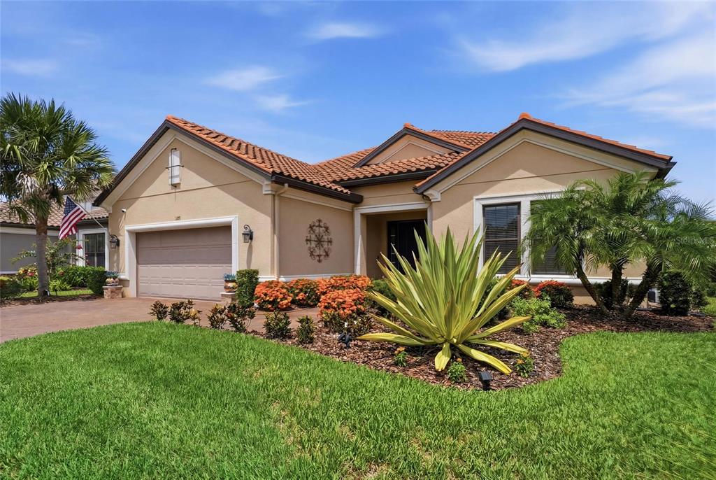 A single-story suburban house with a tan stucco exterior, tile roof, and landscaped front yard — 5288 RUSHMERE COURT, PALMETTO, FL