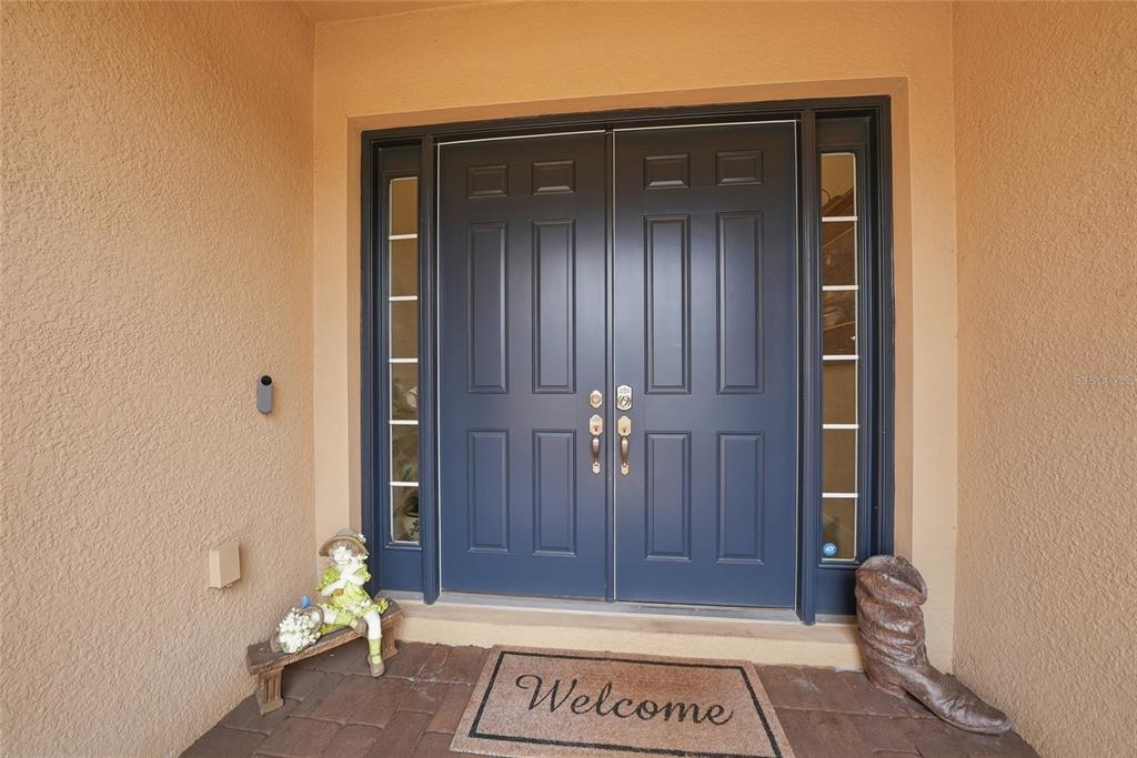 A dark blue double front door with sidelights and a welcome mat on a porch — 5288 RUSHMERE COURT, PALMETTO, FL