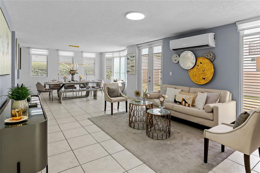 An open-concept living and dining room features tile flooring, neutral furniture, and wall-mounted decor — 59 VIA SOL, CAGUAS, PR
