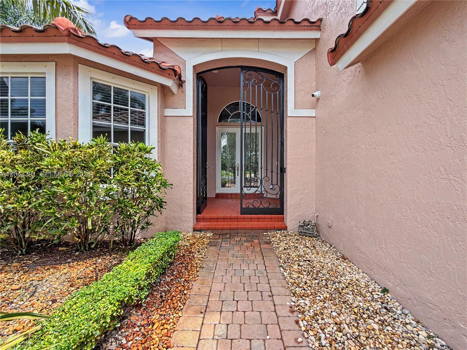 A brick walkway leads to a front entrance with a decorative metal security gate — 18900 SW 32nd Ct, Miramar FL 33029, MIRAMAR, FL