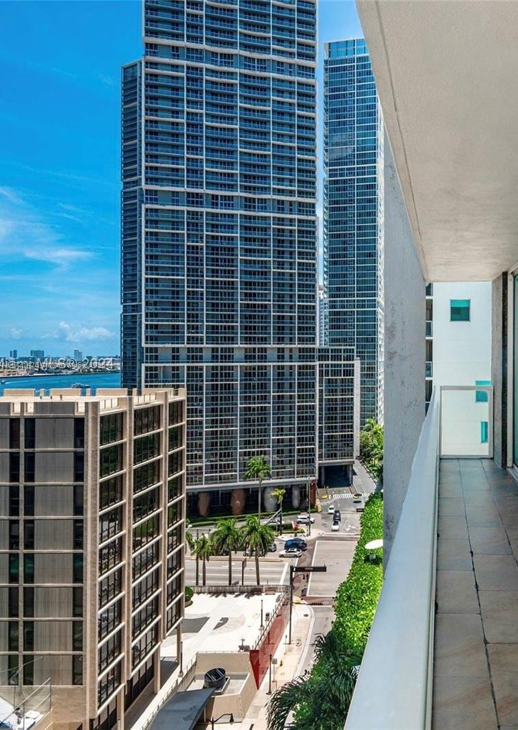 A view from a balcony overlooking a city street, palm trees, and several tall skyscrapers — 55 SE 6th St # 1507, Miami FL 33131, MIAMI, FL
