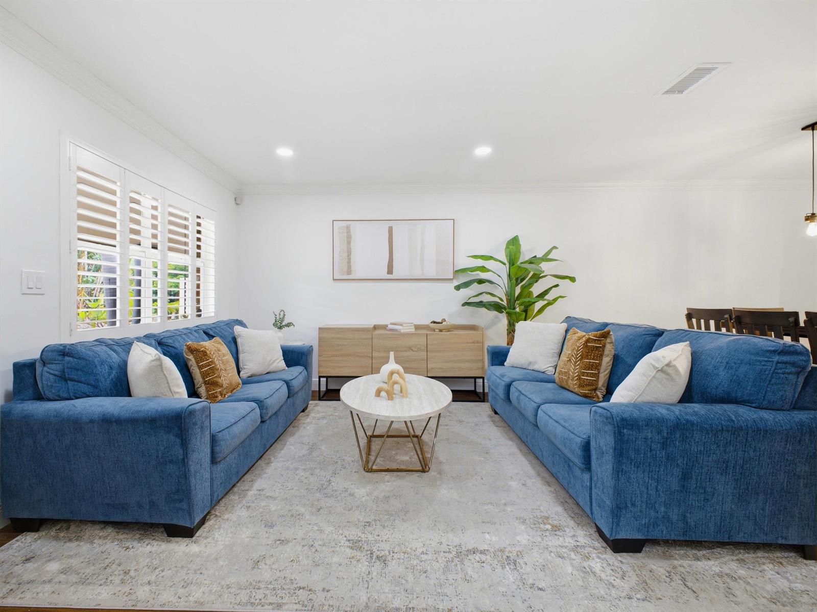 A living room features two blue sofas, a round coffee table, and a wooden sideboard — 5120 NE 22nd Avenue, Lighthouse Point FL 33064, LIGHTHOUSE POINT, FL
