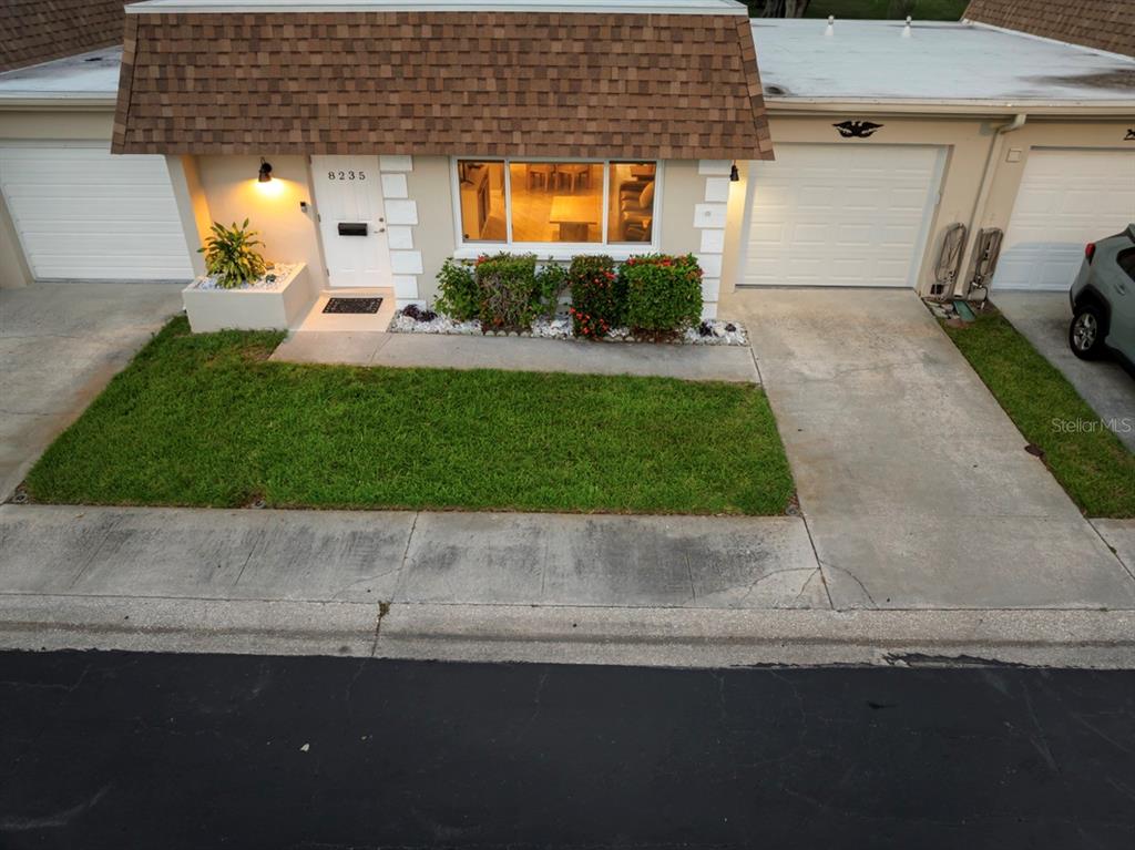 An aerial view shows the exterior of a single-story townhouse with a brown shingled roof — 8235 BURGUNDY DRIVE N UNIT 3, PINELLAS PARK, FL