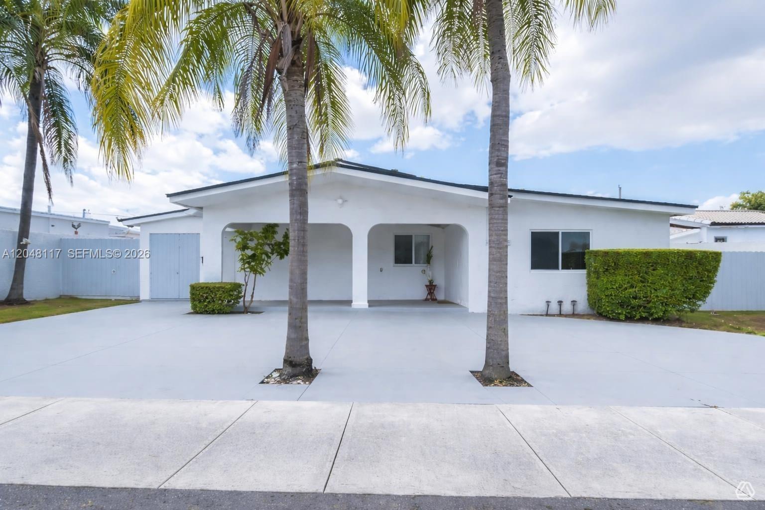 A white single-story house features a covered front porch, two palm trees, and a concrete driveway — 114 SW SW 57th Ct, Miami FL 33144, MIAMI, FL