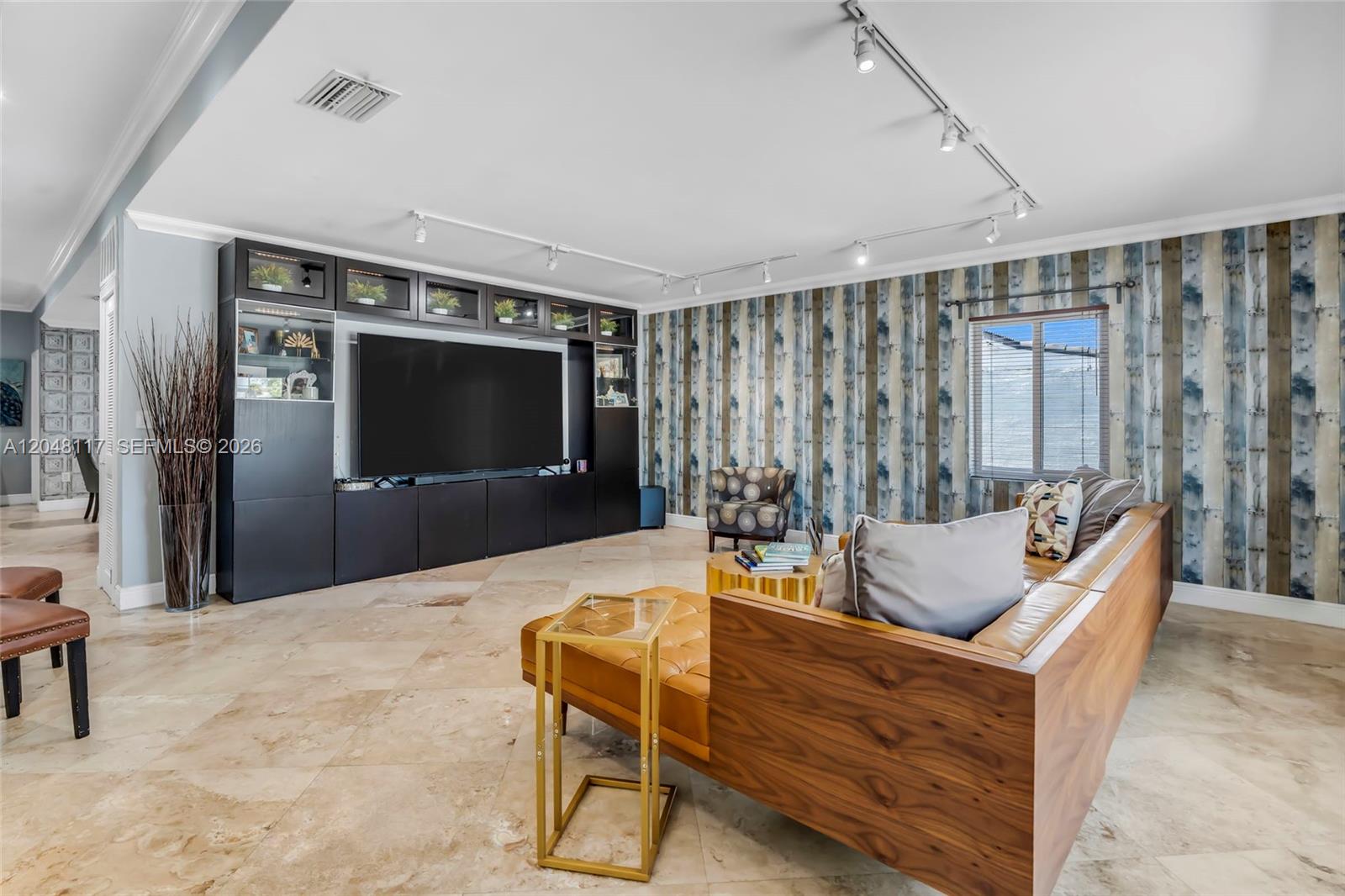 A living room features a large media wall, patterned wallpaper, and a leather sectional sofa — 114 SW SW 57th Ct, Miami FL 33144, MIAMI, FL
