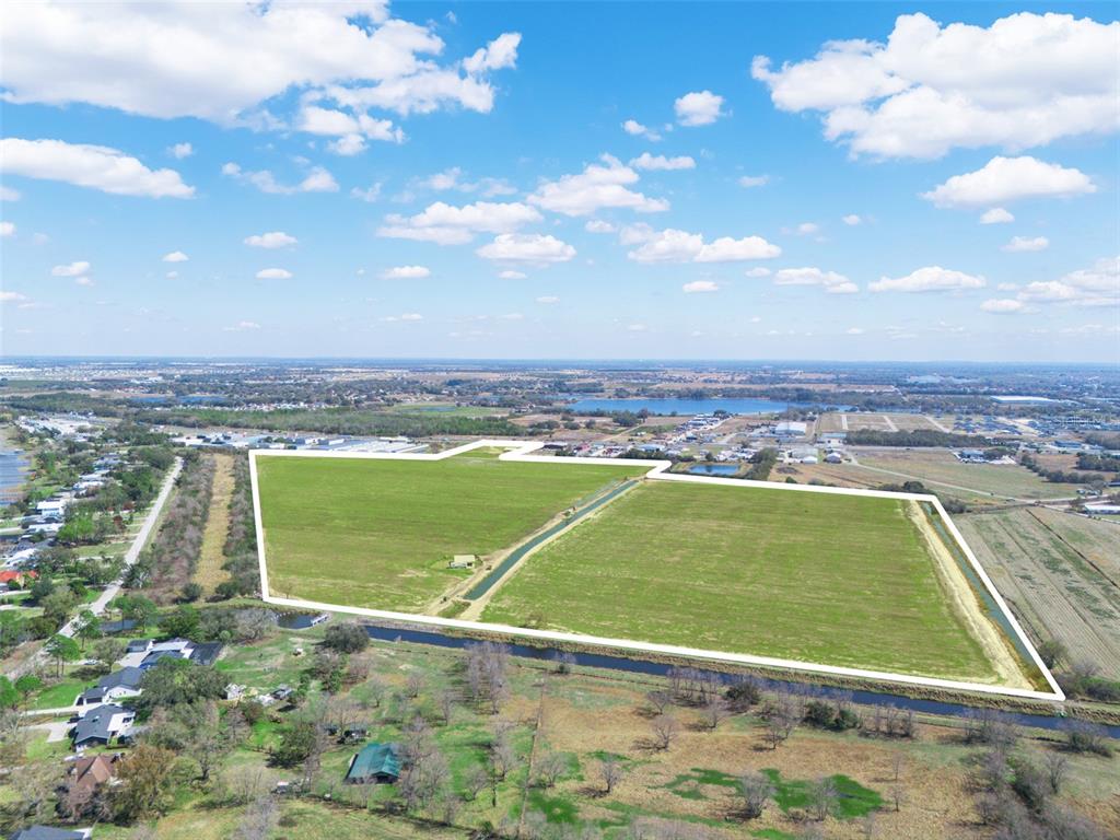 An aerial view shows a large, rectangular plot of green land outlined in white — US HIGHWAY 27, HAINES CITY, FL