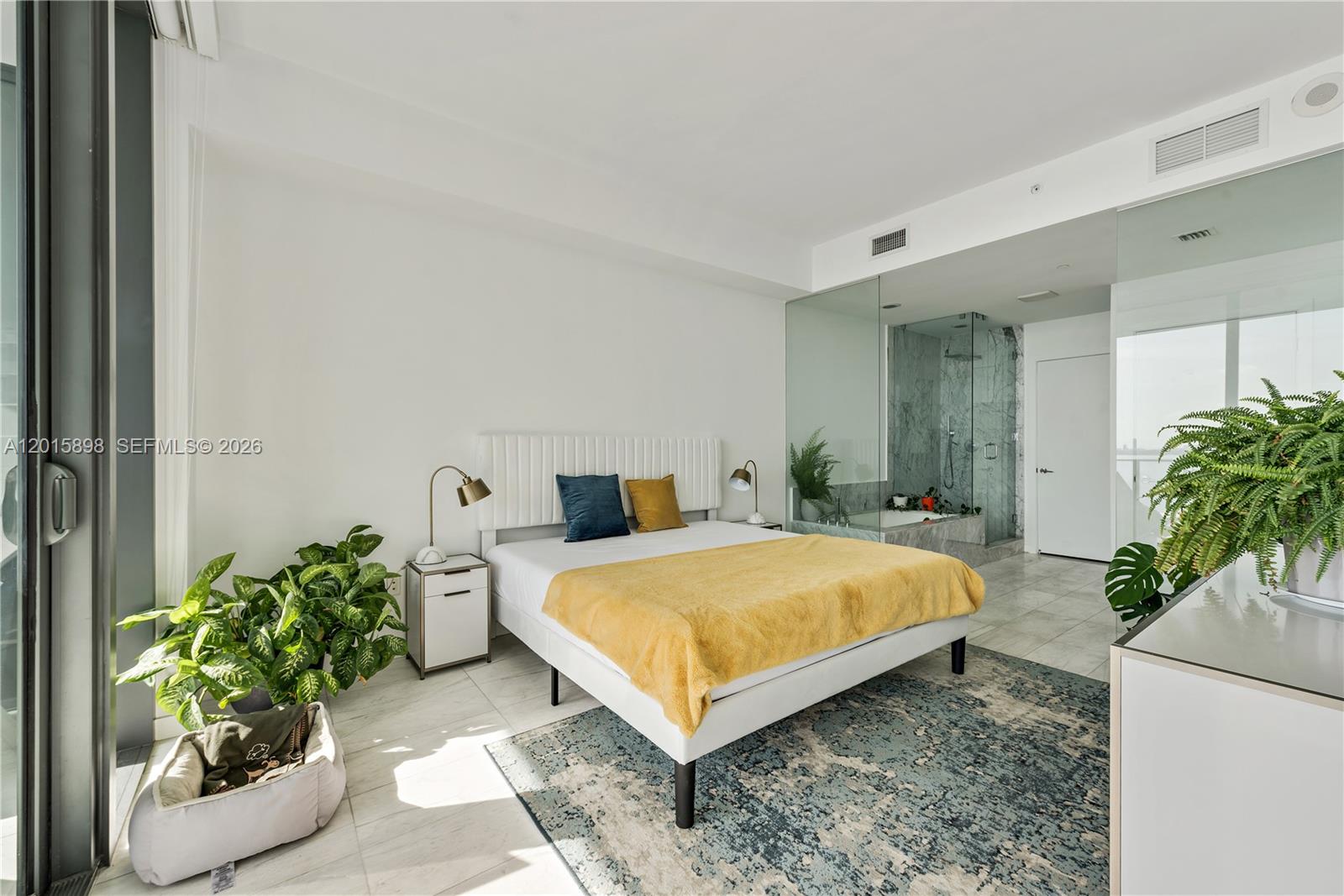 A modern bedroom features a bed, an en-suite glass-enclosed bathroom, and a large balcony door — 480 NE 31st St # 1802, Miami FL 33137, MIAMI, FL