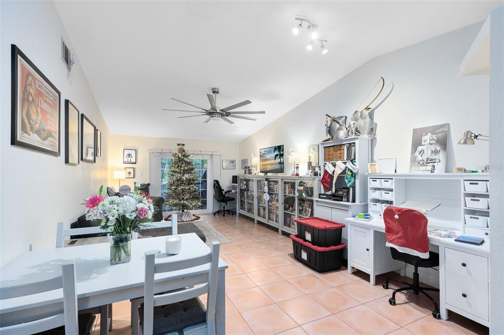 A bright, open-concept living and dining area features tile flooring, a desk, and a Christmas tree — 607-609 CALIFORNIA AVENUE, ST CLOUD, FL