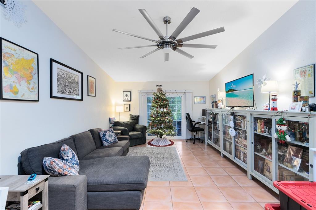 A living room features a gray sectional sofa, a Christmas tree, and a large media console — 607-609 CALIFORNIA AVENUE, ST CLOUD, FL