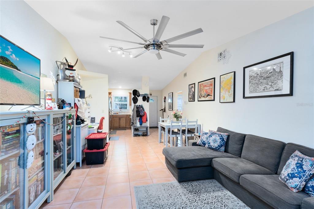 A living room with tile floors, a grey sectional sofa, and a ceiling fan — 607-609 CALIFORNIA AVENUE, ST CLOUD, FL