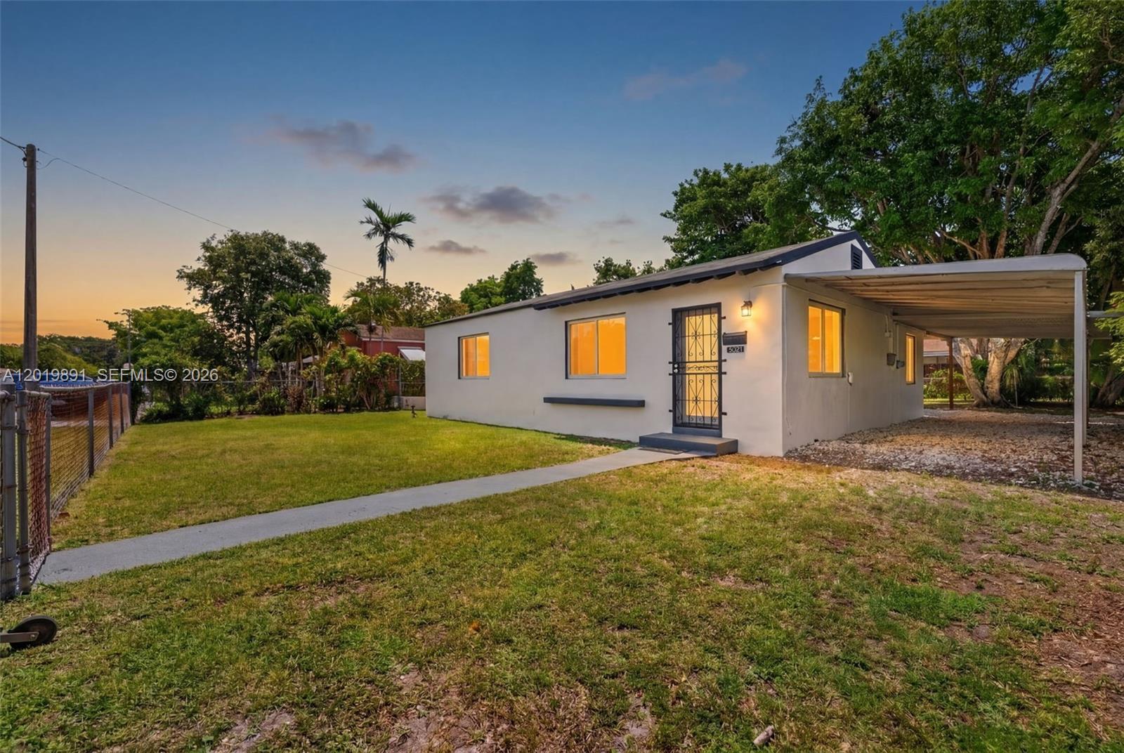 A single-story house with a white exterior, a metal carport, and a front lawn — 280 NW 101st St, Miami FL 33150, MIAMI, FL