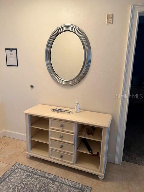 A light-colored wooden console table with drawers and shelves sits below an oval wall mirror — 102 YACHT HARBOR DRIVE UNIT 264, PALM COAST, FL