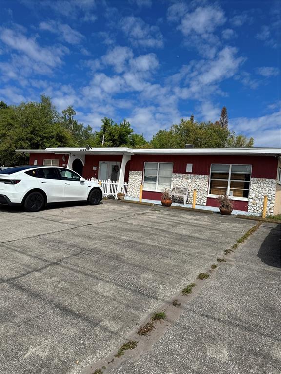 A single-story building with red siding, stone accents, and a white car parked in front — 1025 W OAK RIDGE ROAD, ORLANDO, FL