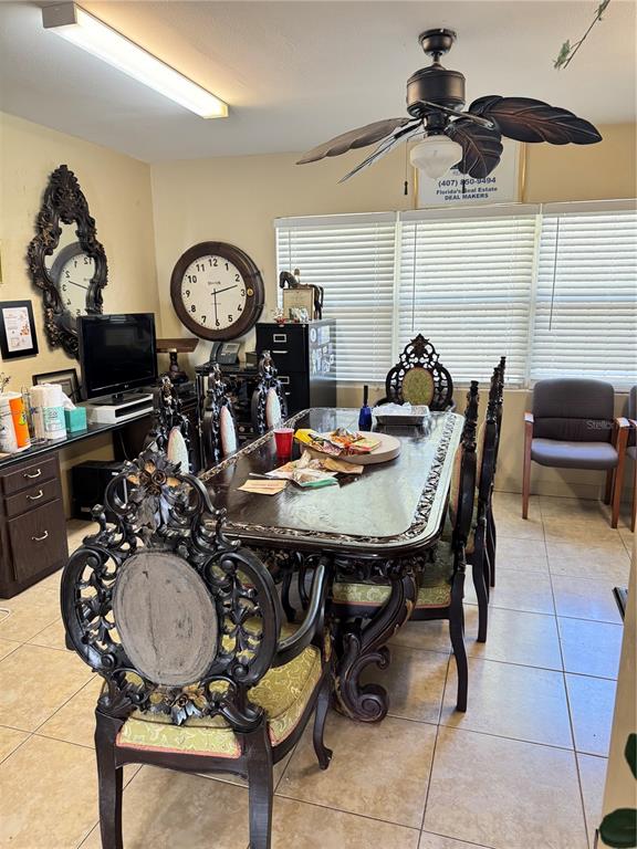A dining room features an ornate dark wood table and chairs, a ceiling fan, and blinds — 1025 W OAK RIDGE ROAD, ORLANDO, FL