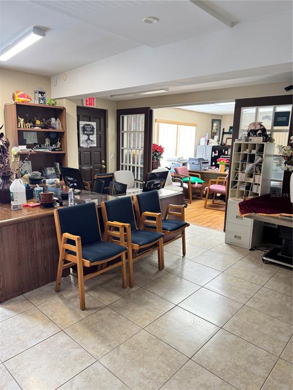 An office waiting area features three wooden chairs, a reception desk, and an adjacent workspace — 1025 W OAK RIDGE ROAD, ORLANDO, FL