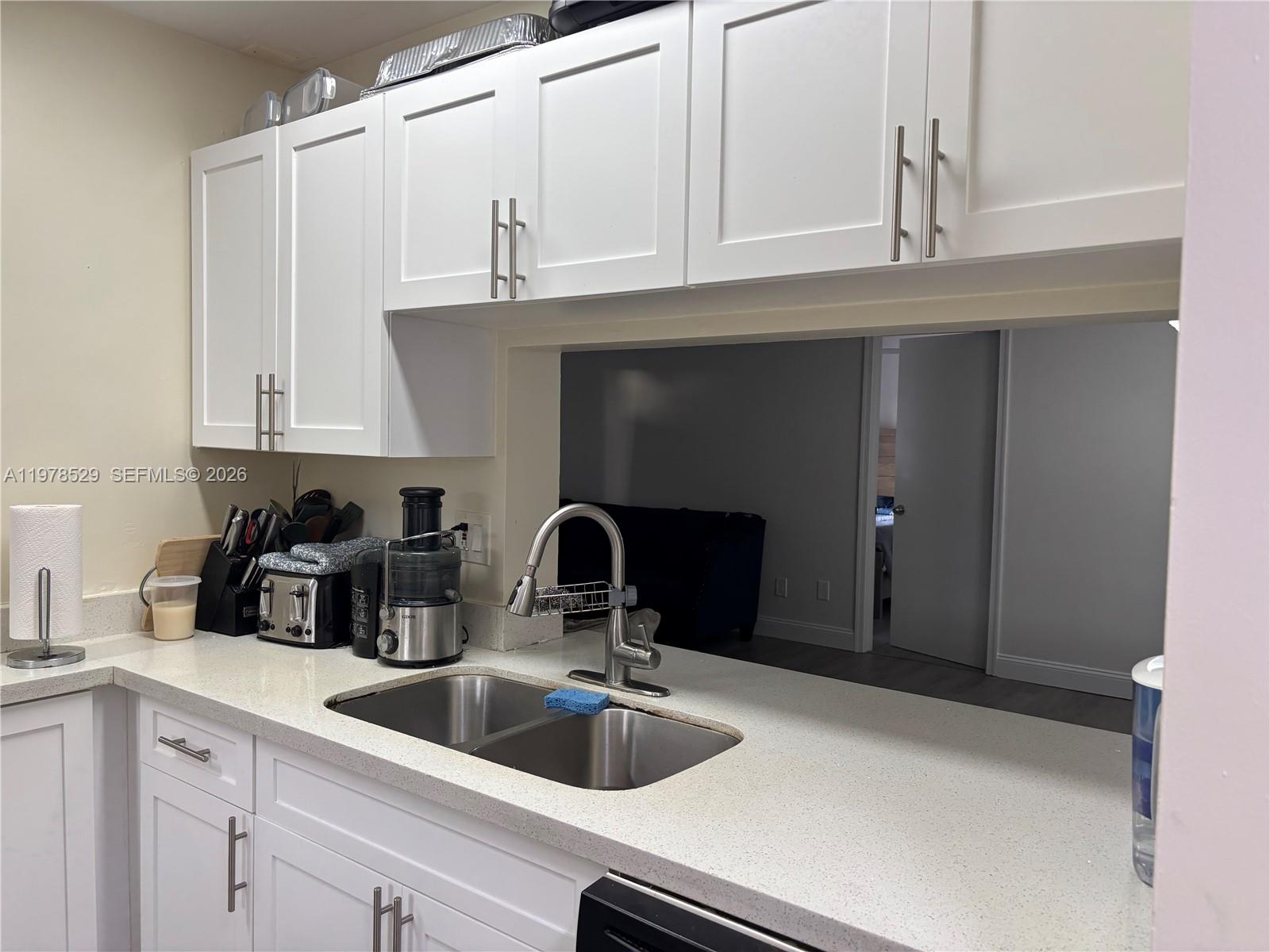 A kitchen features white cabinets, a stainless steel double sink, and speckled countertops — 3615 NW 94th Ave # 8F, Sunrise FL 33351, SUNRISE, FL
