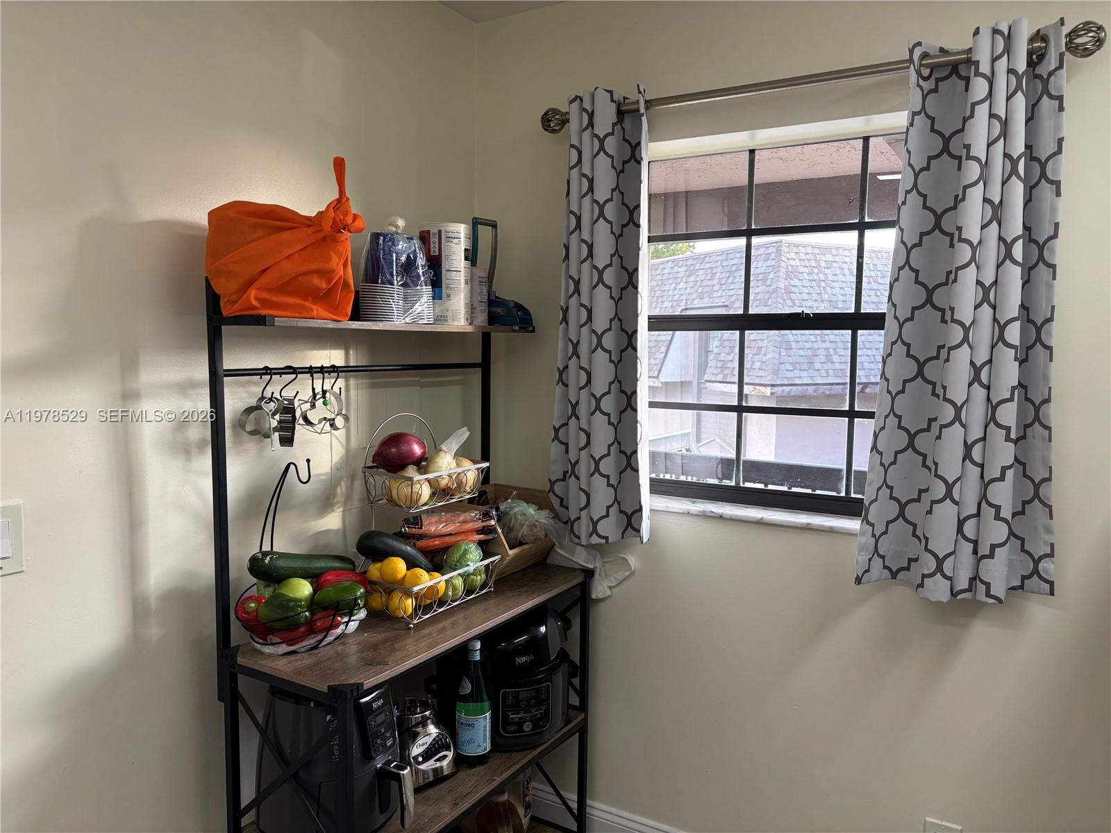 A kitchen area features a metal and wood shelving unit holding produce and small appliances — 3615 NW 94th Ave # 8F, Sunrise FL 33351, SUNRISE, FL