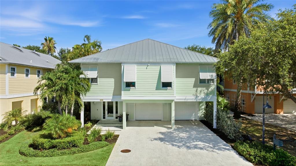 A light green two-story house with a metal roof and a paved driveway — 392 FIREHOUSE LANE, LONGBOAT KEY, FL