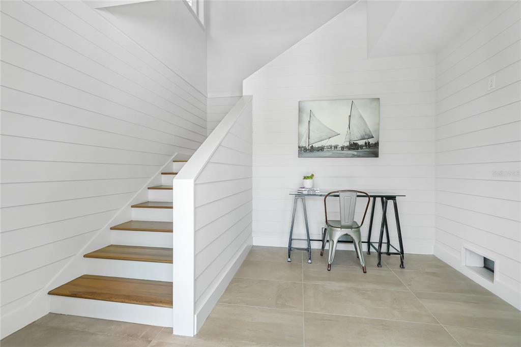 A staircase with wood treads sits beside a small desk area with shiplap walls — 392 FIREHOUSE LANE, LONGBOAT KEY, FL