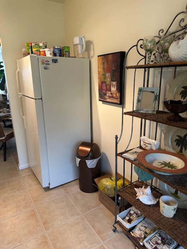 A white refrigerator stands next to a brown trash can and a decorative metal shelf — 550 NW 78th Avenue # 204, Margate FL 33063, MARGATE, FL
