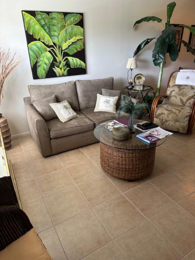 A living room features a brown sofa, a round wicker coffee table, and tropical decor — 550 NW 78th Avenue # 204, Margate FL 33063, MARGATE, FL