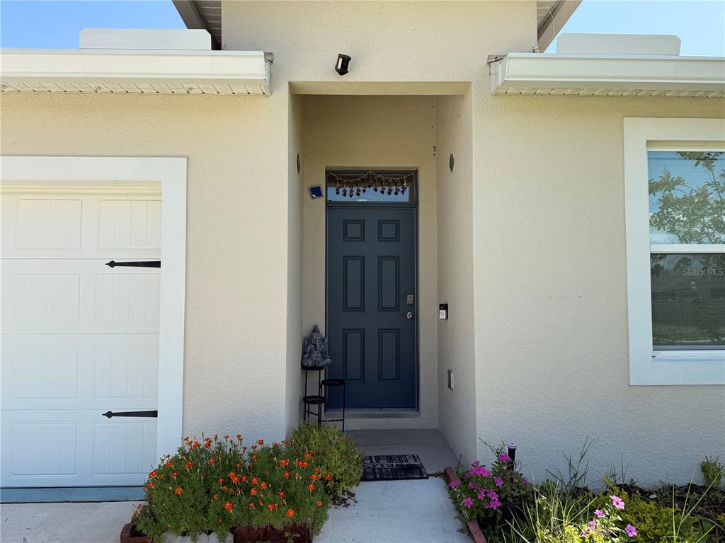 The exterior of a house features a dark blue front door and a garage — 2250 HIDDEN PALM DRIVE, SANFORD, FL