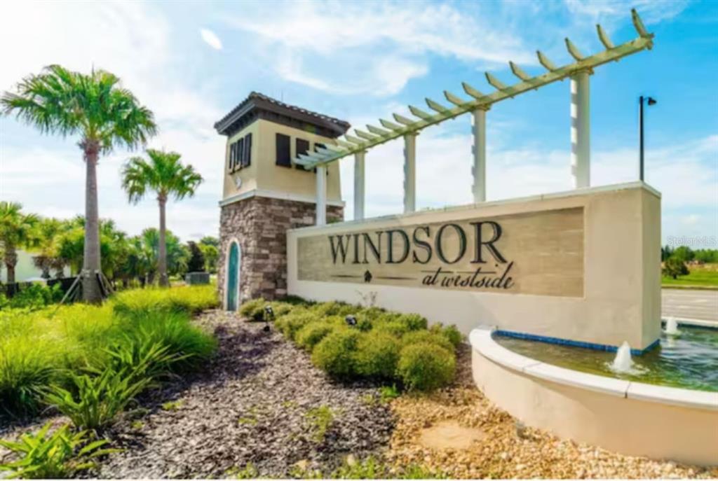 A stone and stucco monument sign for Windsor at Westside stands near a small fountain — 1744 LIMA AVENUE, KISSIMMEE, FL