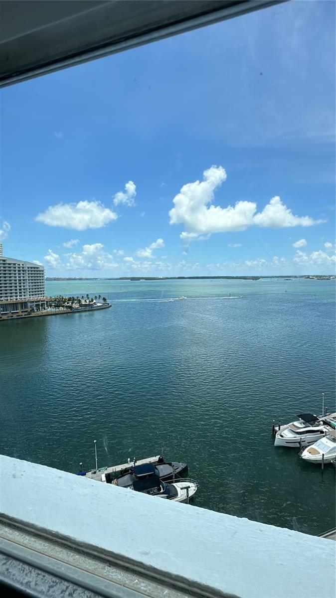 A high-angle view shows a bay with boats, a large building, and a blue sky — 905 Brickell Bay Dr # B, Miami FL 33131, MIAMI, FL