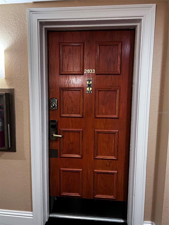 A wooden front door with a keypad lock and the number 2933 installed — 36750 US HIGHWAY 19 N UNIT 19-115, PALM HARBOR, FL