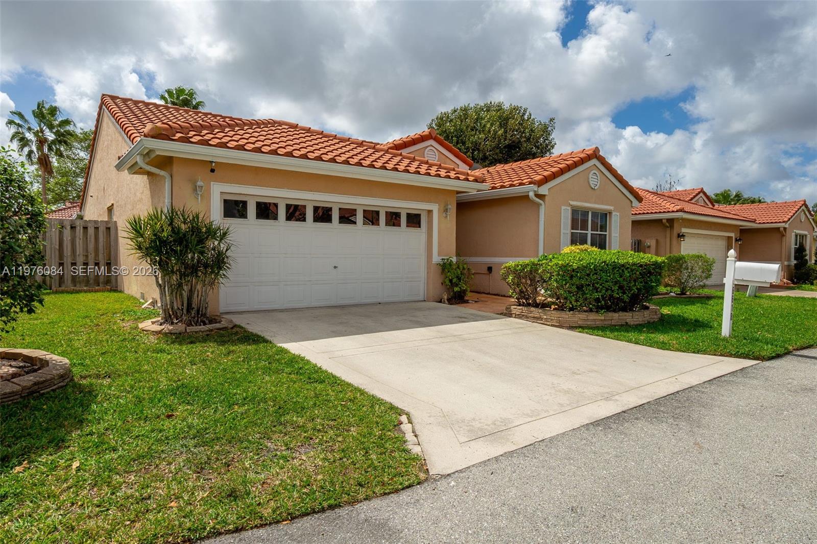 A single-story house with a terracotta tile roof, beige stucco walls, and a concrete driveway — 6618 Skipper Ter, Margate FL 33063, MARGATE, FL