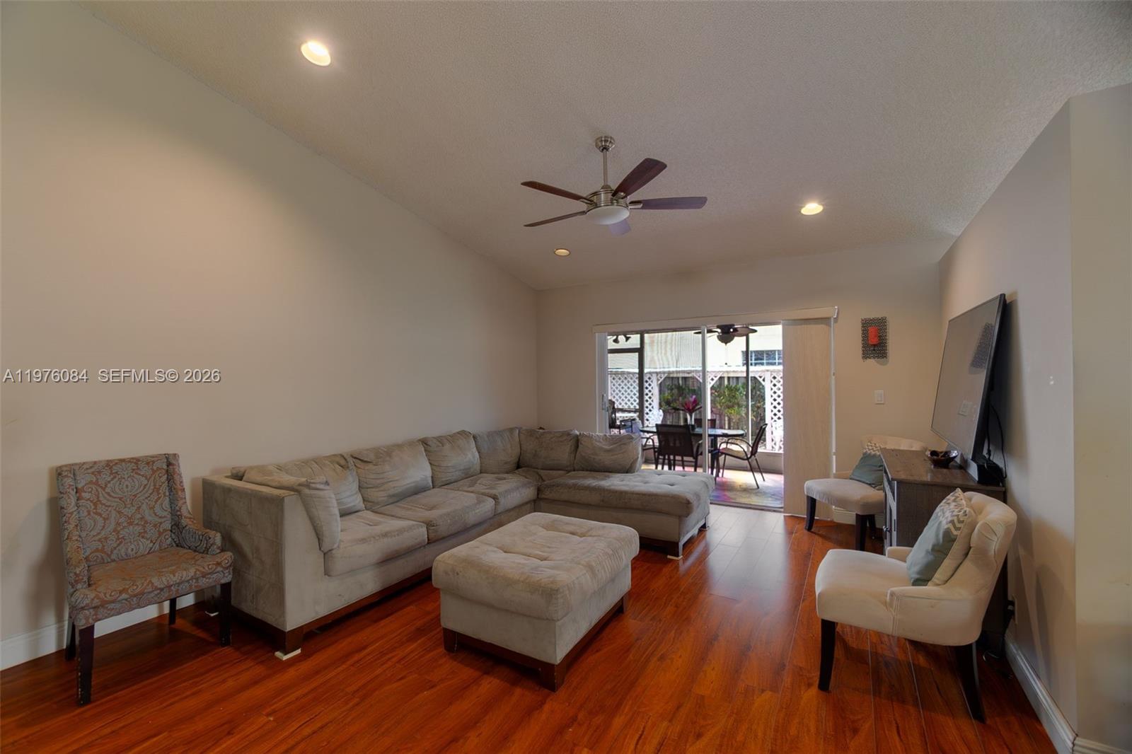 A living room features a sectional sofa, an ottoman, two accent chairs, and hardwood flooring — 6618 Skipper Ter, Margate FL 33063, MARGATE, FL