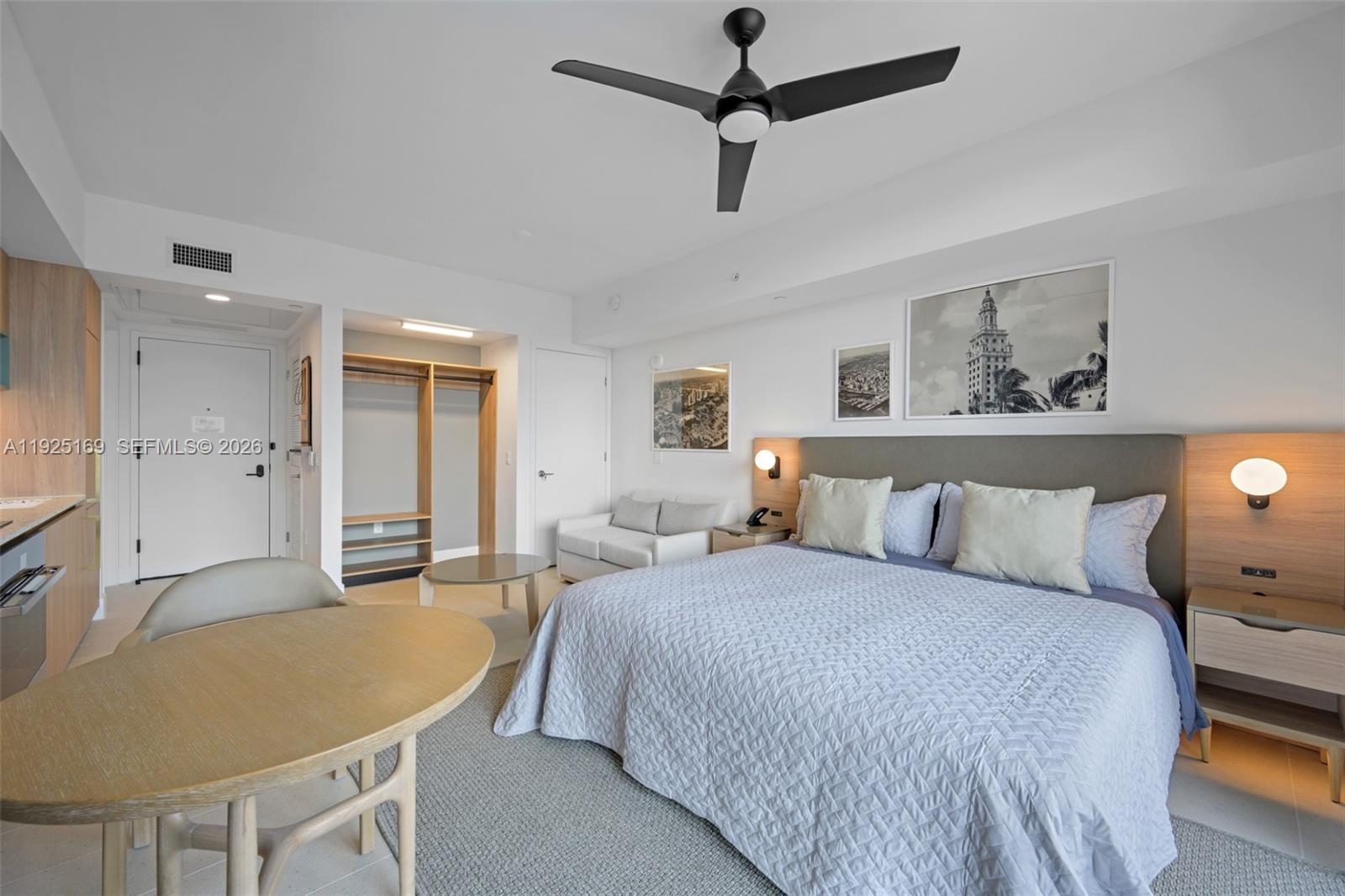 A bedroom features a bed, a small seating area, a dining table, and a closet — 159 NE 6th St # 3810, Miami FL 33132, MIAMI, FL