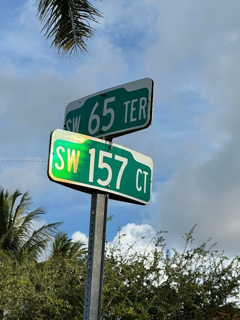 A street sign displays the intersection of SW 65 Terrace and SW 157 Court — 157th CT SW 65th TERRACE, Miami FL 33193, MIAMI, FL