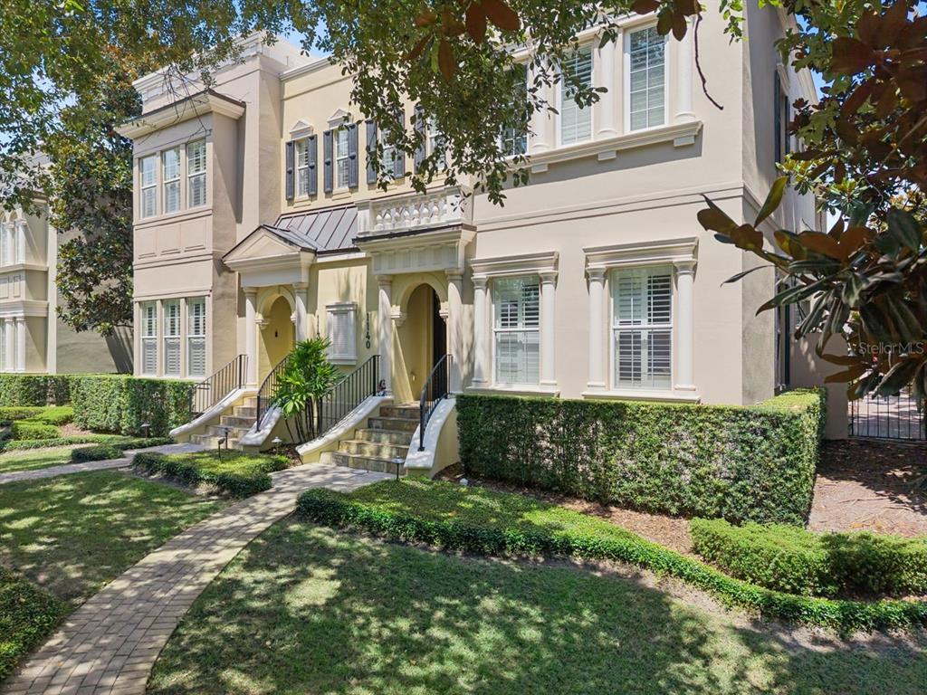 A two-story stucco townhouse with arched entryways, stone steps, and manicured hedges — 1138 S PENNSYLVANIA AVENUE, WINTER PARK, FL