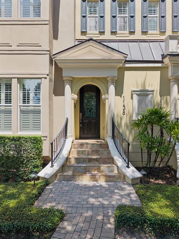 A stone staircase with black railings leads to the arched front door of a townhouse — 1138 S PENNSYLVANIA AVENUE, WINTER PARK, FL