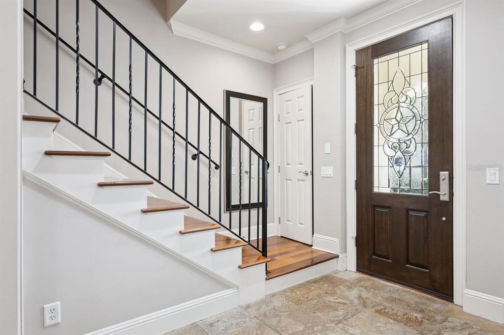 An entryway features a tiled floor, a wooden front door, and a staircase with railing — 1138 S PENNSYLVANIA AVENUE, WINTER PARK, FL