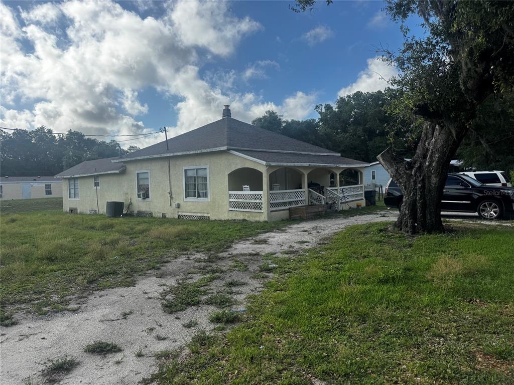 A single-story house with a yellow stucco exterior and a covered front porch — 7001 COLUMBIA DRIVE, MULBERRY, FL