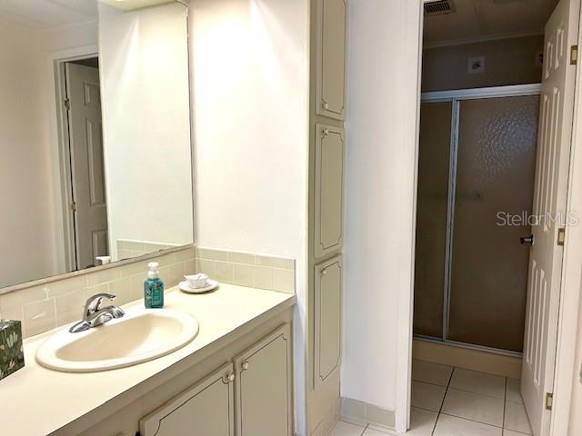 A bathroom features a vanity with a sink, a mirror, and a separate shower stall — 347 MARINER DRIVE, NORTH PORT, FL
