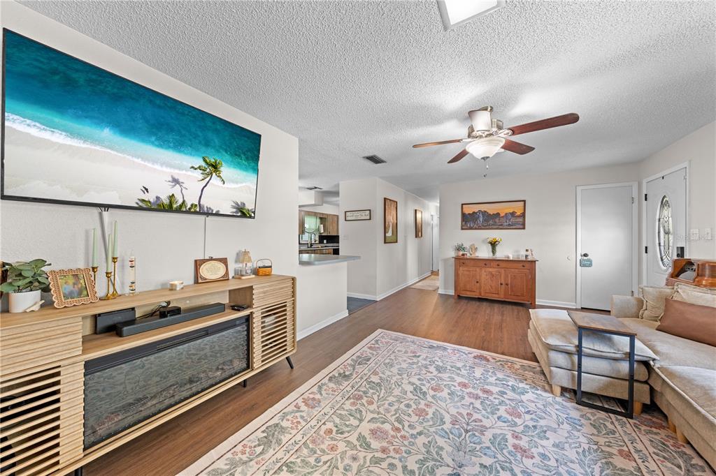 A living room features a large television, a fireplace console, and a sectional sofa — 463 CHESTNUT COURT, DELTONA, FL