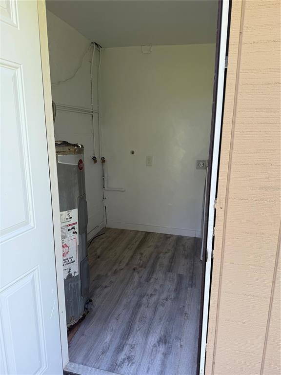 A utility room features a water heater, laundry hookups, and light-colored wood-look flooring — 305 ANN STREET, EDGEWATER, FL