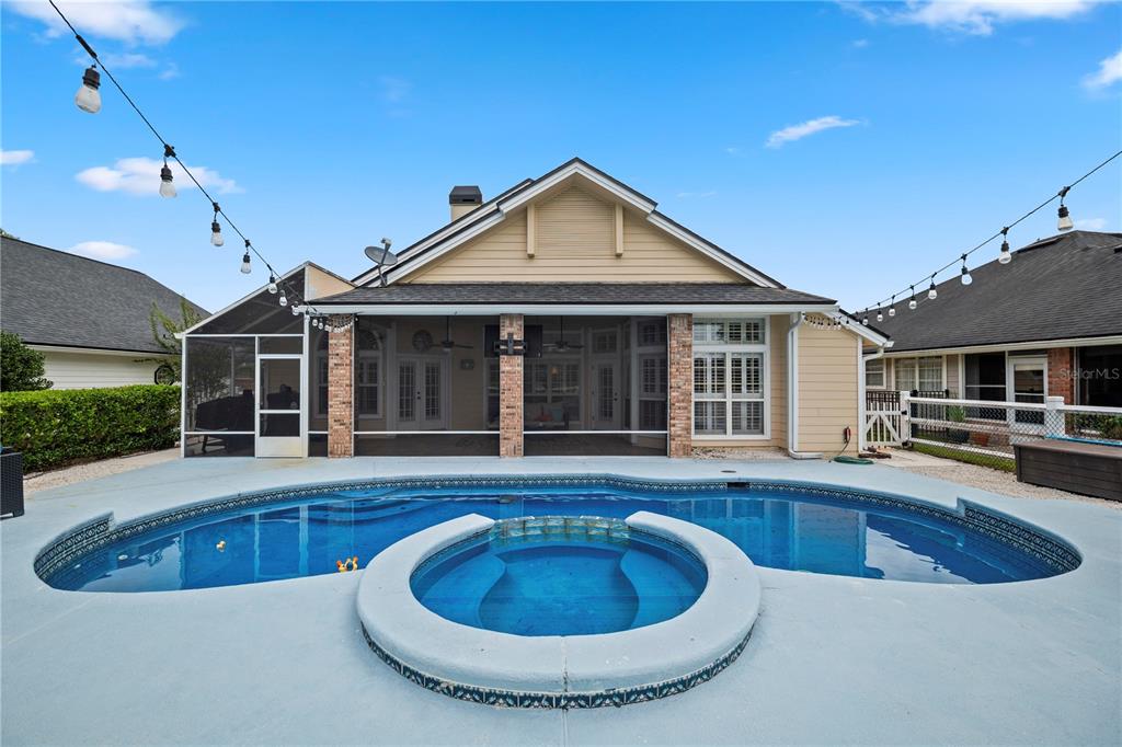 A backyard features a swimming pool with an attached spa and a covered patio area — 3729 CONSTANCIA DRIVE, GREEN COVE SPRINGS, FL