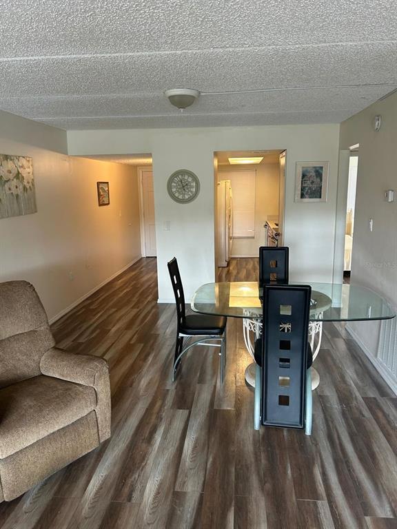 A dining area with a glass table and black chairs sits near a kitchen entrance — 12760 INDIAN ROCKS ROAD UNIT 1048, LARGO, FL