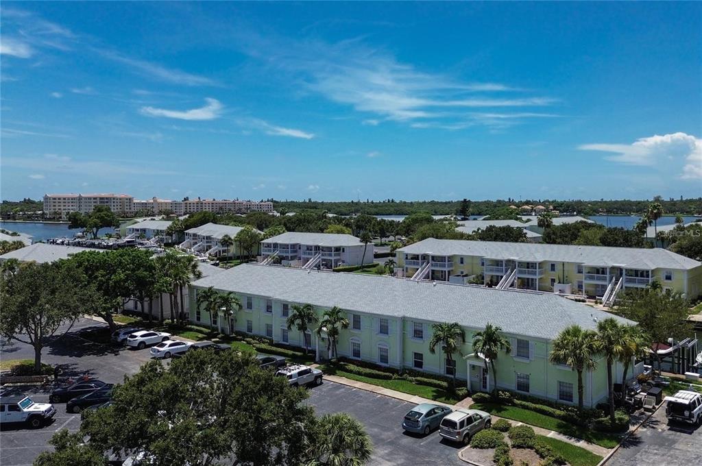 An aerial view of a multi-story apartment complex with parking lots and surrounding trees — 5111 COQUINA KEY DRIVE SE UNIT C, ST PETERSBURG, FL