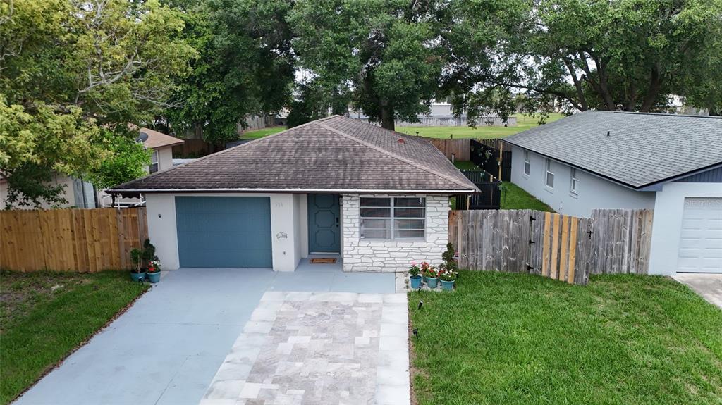 An aerial view of a single-story house with a blue garage door and stone facade — 536 HIBISCUS WAY UNIT 7B, ORLANDO, FL