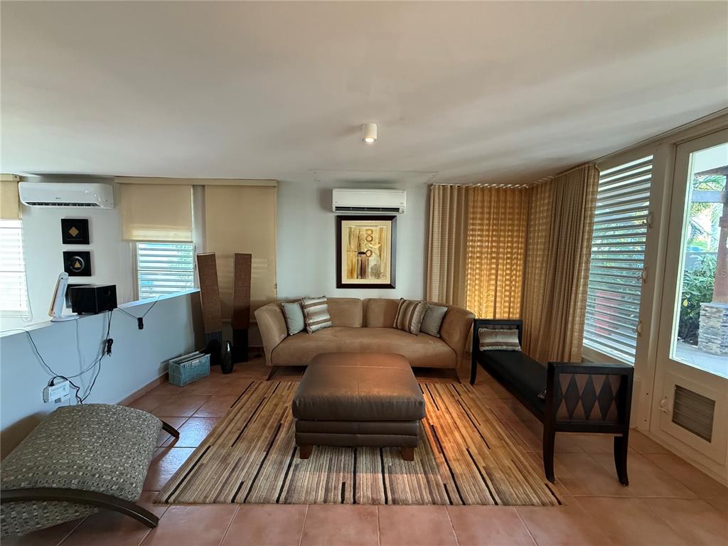 A living room features a tan sofa, a large ottoman, and tile flooring — . TOPACIO STREET UNIT F-22, DORADO, PR