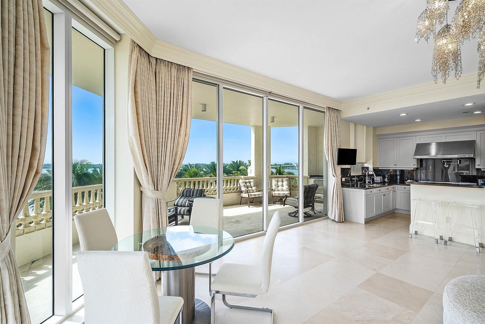 A bright dining area and kitchen feature floor-to-ceiling windows overlooking a balcony and water — 3000 S Ocean Boulevard # 402, Palm Beach FL 33480, PALM BEACH, FL