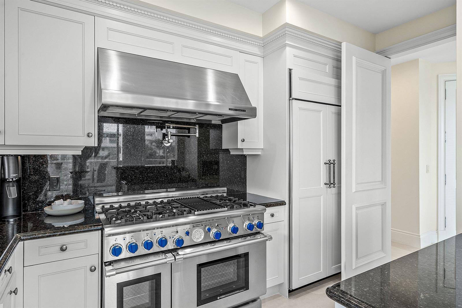A kitchen features white cabinetry, a stainless steel range with blue knobs, and granite countertops — 3000 S Ocean Boulevard # 402, Palm Beach FL 33480, PALM BEACH, FL