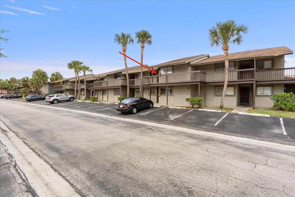 A two-story apartment building with a balcony and palm trees in a parking lot — 6332 NEWTOWN CIRCLE UNIT 32B5, TAMPA, FL